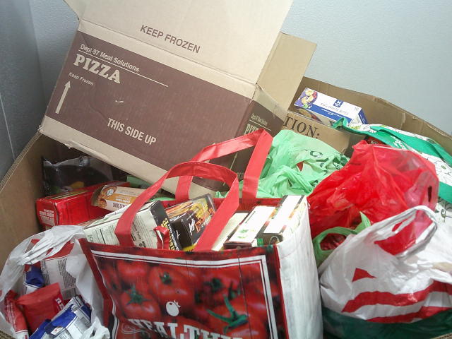 Cardboard container filled with boxes and bags of food.